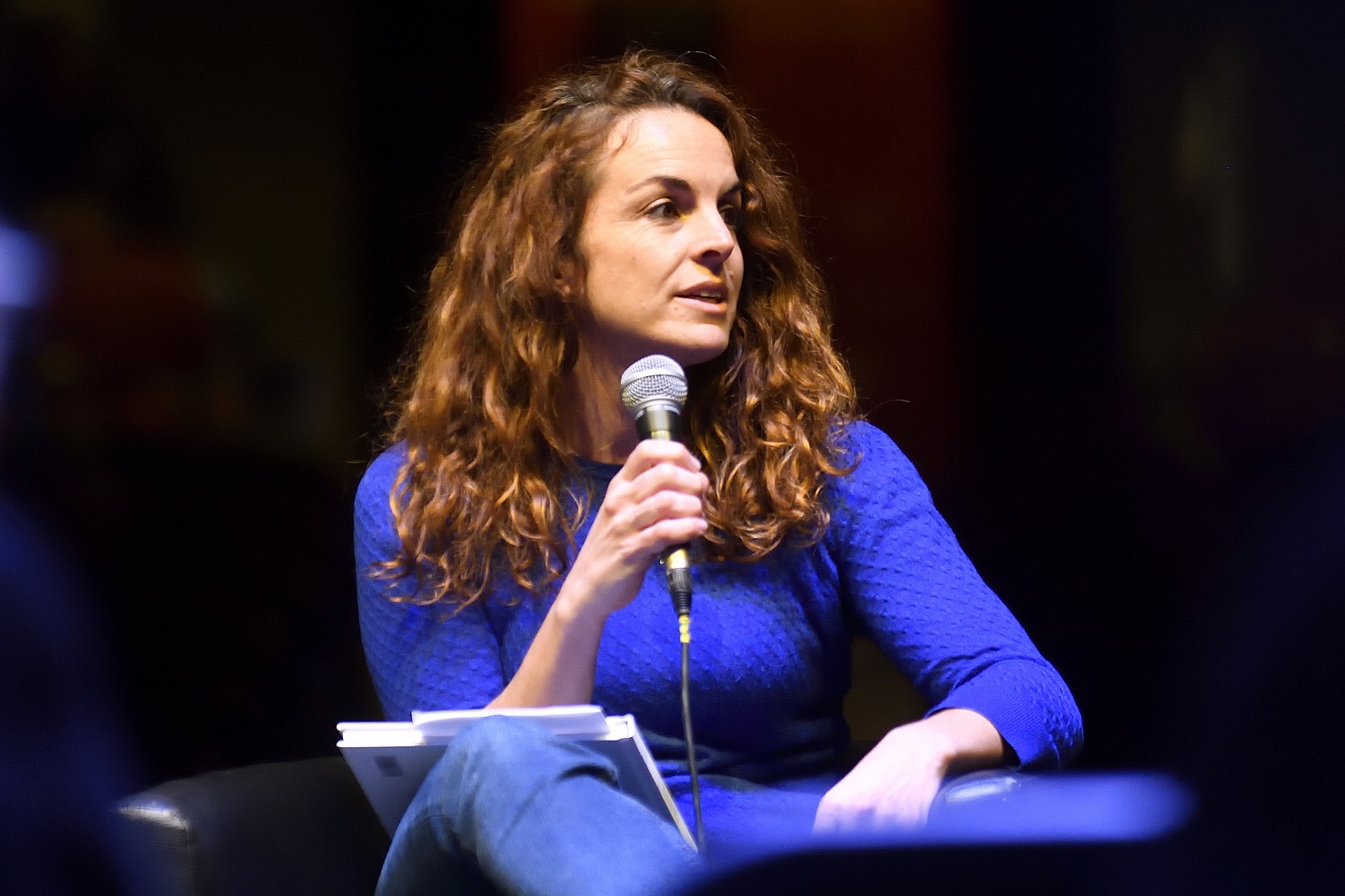 Marta Pulgar parlant en públic, amb un micròfon a la mà